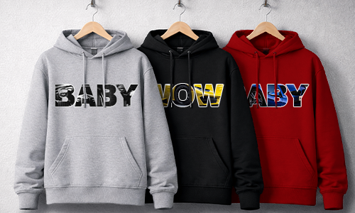 Drei Hoodies auf Bügeln: Grau BABY mit Camouflage-Buchstaben, Schwarz WOW metallisch gelb, Rot BABY mit blauen grafischen Akzenten