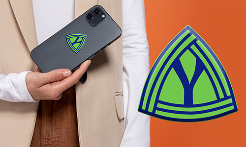 Persona sosteniendo un teléfono móvil con logo en triángulo verde-azul personalizado – emblema correspondiente sobre fondo naranja.
