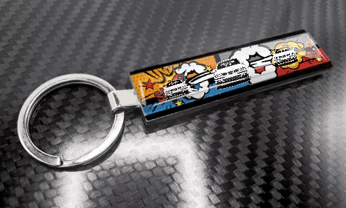 XL-Schlüsselanhänger im Comic-Stil mit farbigem Nummernschild-Design auf einer carbonstrukturierten Oberfläche