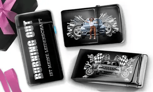 Drei schwarze Geldbörsen mit Auto-Designs. Eine trägt die Aufschrift „Burning Out ist meine Leidenschaft“, eine andere zeigt ein Auto mit Kolben und einer Person, und die dritte zeigt ein Auto mit karierten Flaggen und Kolben. In der Ecke liegt eine violette Schleife.