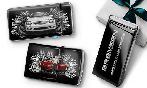 Drei elegante schwarze Geldbörsen mit Bildern von Autos und Zahnrädern, platziert neben einer Geschenkbox. Auf einer steht „Bremsen“. Das Design ist dynamisch und modern.