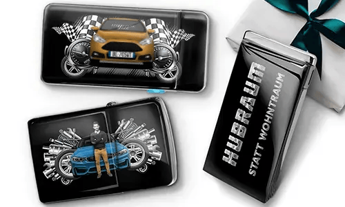 Geschenkset mit Auto-Themen-Metallbehältern, die Bilder eines grünen Sportwagens, karierten Flaggen und Motor-Motiven zeigen. Enthält ein Zigarettenetui mit der Aufschrift „Hubraum Statt Wohntraum“.