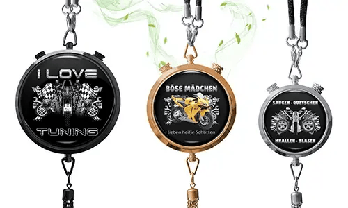 Three metallic pendants with chains: black with checkered flags, rose gold with yellow motorcycle, silver with engine graphic and bold German text