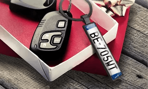 Metallnøkkelring med nummerskilt viser graverte tall ved siden av bilnøkler