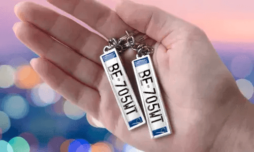 Llaveros con placa personalizada y números personalizados, sostenidos en la mano