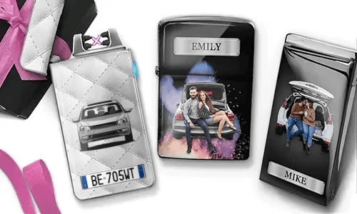 Drei personalisierte Zigarettenetuis sind zu sehen. Das erste zeigt ein Auto mit Kennzeichen. Das zweite zeigt ein Paar, das auf einem Auto sitzt, mit der Aufschrift „Emily“ vor farbenfrohem Hintergrund. Das dritte zeigt ein Paar im Kofferraum eines Autos, mit der Aufschrift „Mike“. Rosafarbene Schleifenakzente sind sichtbar.