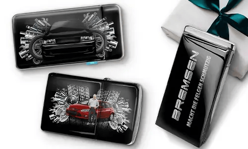 Three sleek black wallets with images of cars and gears, placed near a gift box. 