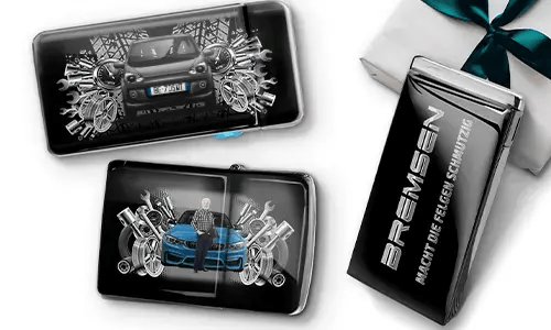 Three automotive-themed items featuring car illustrations and machinery motifs, arranged with a gift box tied with a green ribbon on the side.