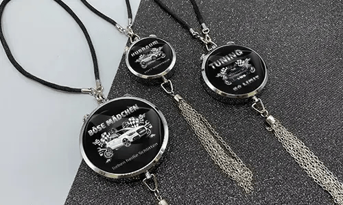 Three black pendants with chains: each with car graphic and German tuning slogan on glittery surface