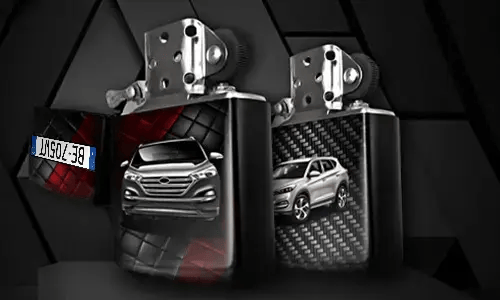Two metallic lighters with silver SUV designs: one front view on tread background, one side view with carbon texture, small rectangular object in corner
