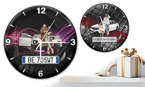 Two wall clocks with family car scenes: left with woman and child at white SUV over purple waves, right with white car and quilted red-black background