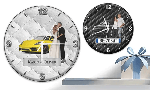 Two wall clocks with formal couple and sports cars: left with yellow car on quilted silver, right with black car on carbon background