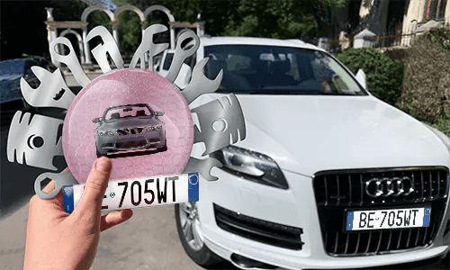 Autoschlüsselanhänger in der Hand mit dem Wagen auf dem Hintergrund individueller schlüsselanhänger