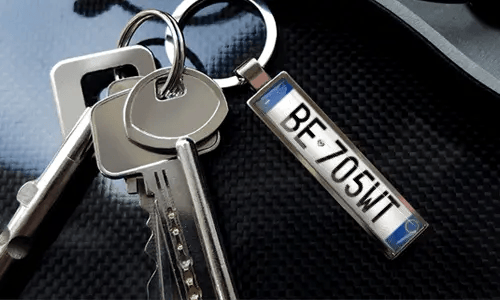 Porte-clés avec pendentif illustrant une voiture et anneau en métal